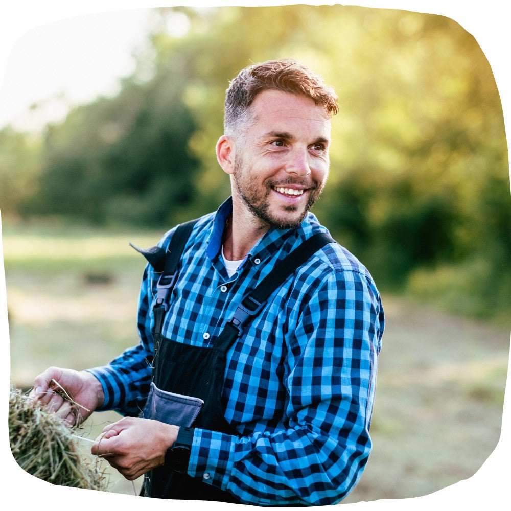 Bauer auf Farm der lächelnd seine Arbei macht
