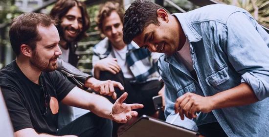 vier Junge Team Mitglieder die über ein Projekt diskutieren