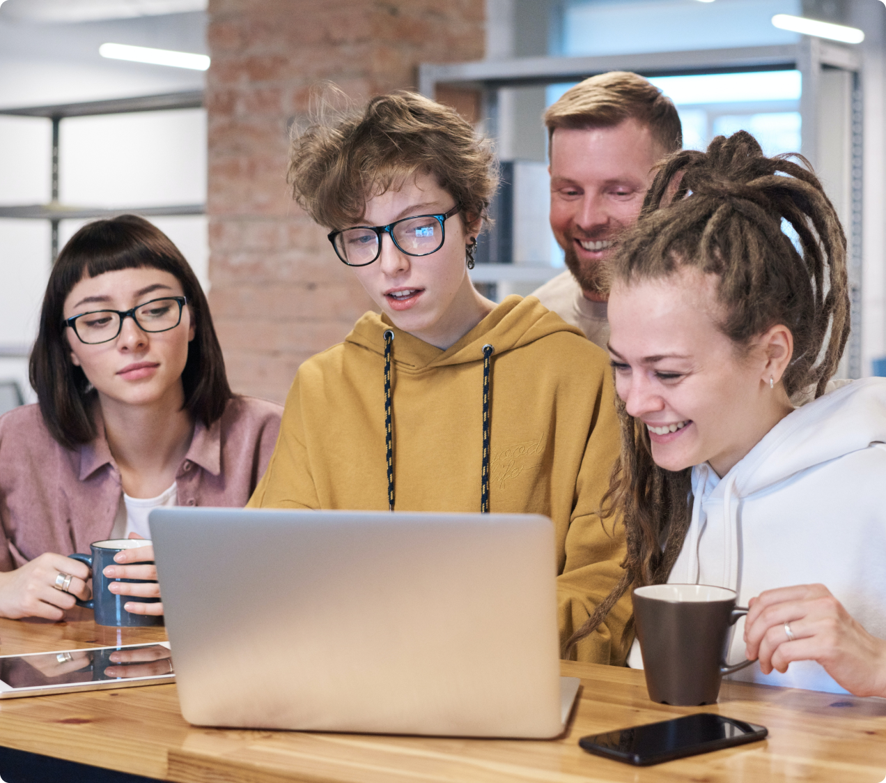 das Junge Team von Safranwunder, engagiert an einem Laptop Kundenwünsche nachzugehen