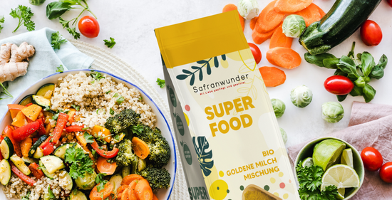 Ein farbiger Gemüseteller mit verschiedenen Gemüsen drum herum, Safranwunder Goldene Milch Superfood neben dran